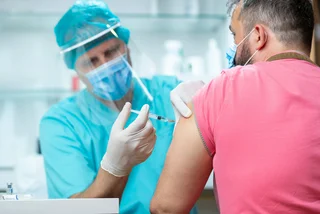 Hospital technician administering a vaccine via iStock / zoranm